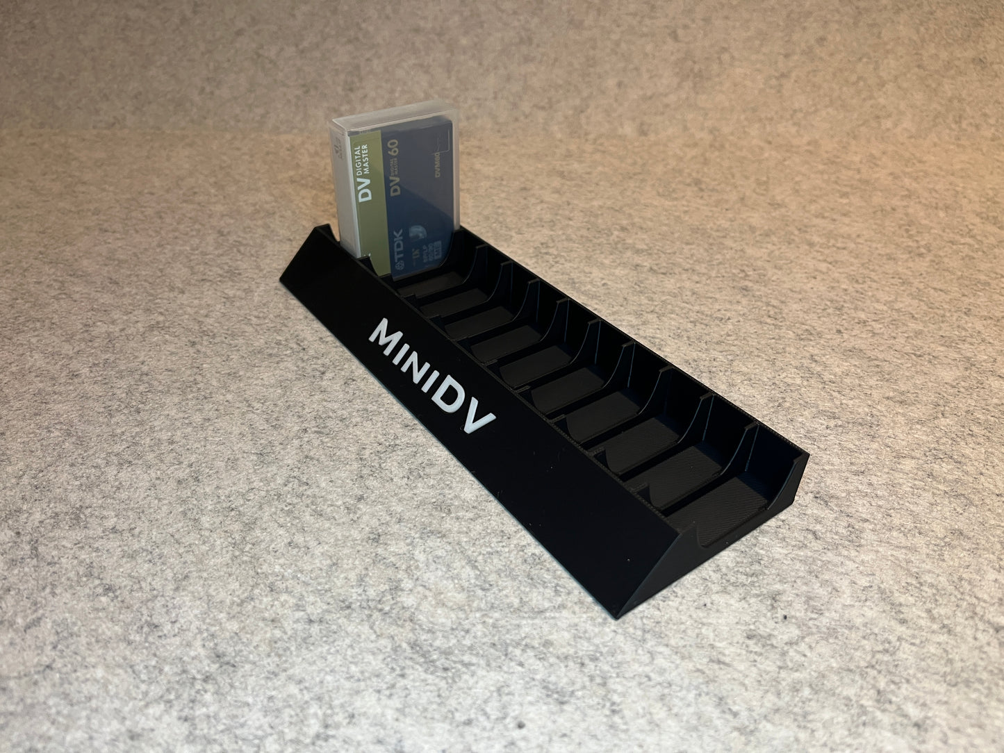 Skrivbordställ för 12 MiniDV-kassettband med MiniDV-text